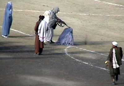 The November 1999 public execution of Zarmeena, a convicted Afghan woman for murdering her husband in cold blood with an ax while he was asleep. The execution was carried out by the Taliban inside the Ghazi stadium in Kabul, Afghanistan. Courtesy Wikicommons.